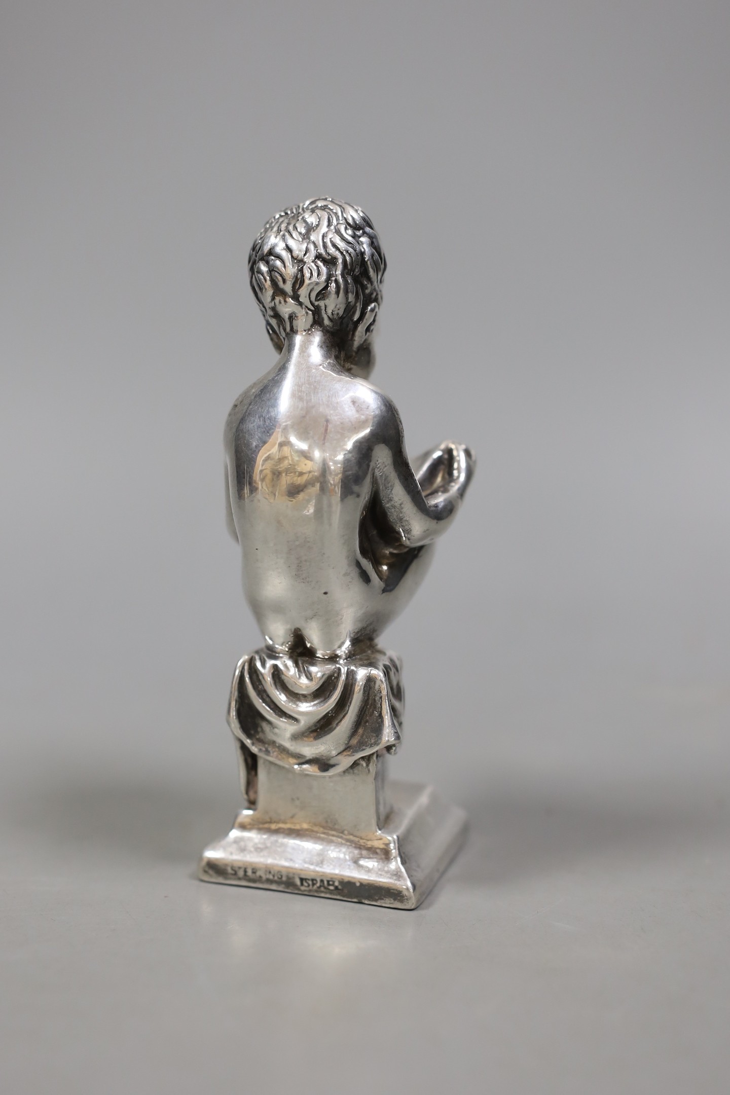 A modern Israeli sterling model of a seated young boy, reading, height 14.1cm.